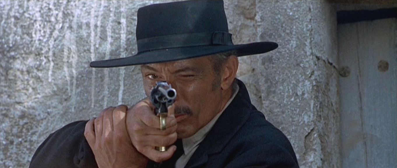 Lee Van Cleef aiming a revolver in a tense standoff